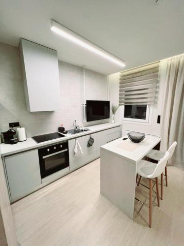 a white kitchen with a table and a counter top at 8 Blocks Apartments in Alexandroupoli