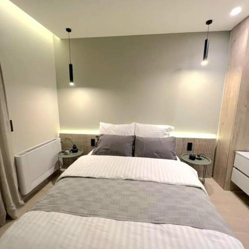 a bedroom with a large bed and two tables at 8 Blocks Apartments in Alexandroupoli