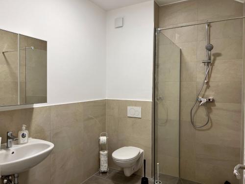 La salle de bains est pourvue d'une douche, de toilettes et d'un lavabo. dans l'établissement Gemütliche Apartments direkt an der Grenze von Hamburg, à Norderstedt