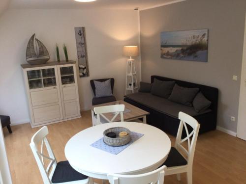 a living room with a white table and a couch at Auszeit am Meer - a73607 in Bastorf