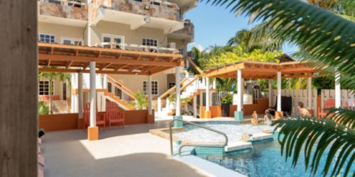 a pool at a hotel with people playing in it at Island Magic Beach Resort in Caye Caulker