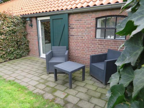 two chairs and a table in front of a building at B&B De Willemshoeve in Wageningen