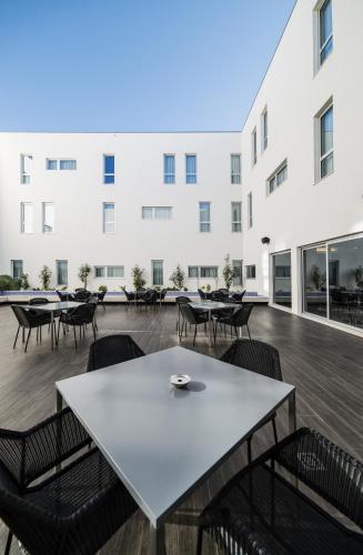 a large white building with tables and chairs at Moov Hotel Évora in Évora