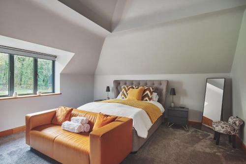 a bedroom with a bed and a couch and a mirror at Woodland House in Belbroughton
