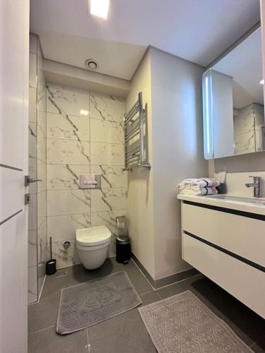 y baño con aseo, lavabo y ducha. en Mükemmel manzaralı balkonlu 2 yatak odalı ve 2 banyolu ultra lüks daire, en Estambul