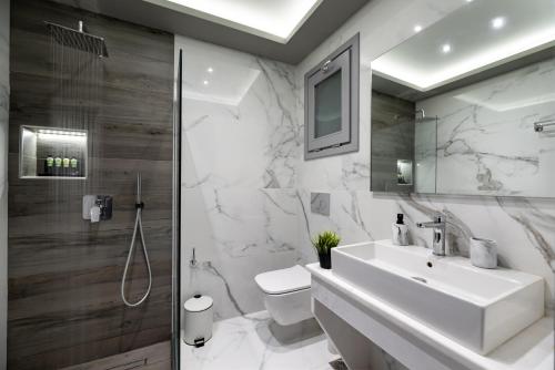 a bathroom with a sink and a toilet and a shower at Filoxenia Luxury Villas in Perissa