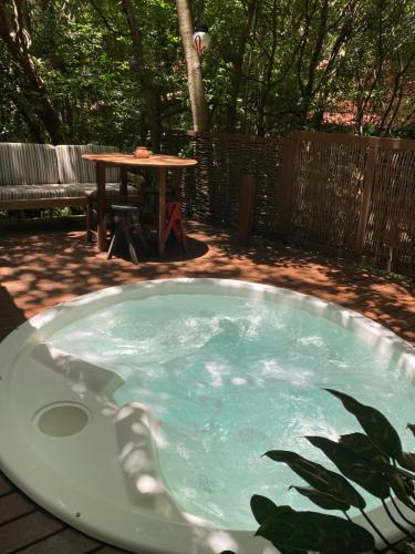 bañera de hidromasaje en un patio con mesa en Chalés Mirante de Pipa, en Pipa