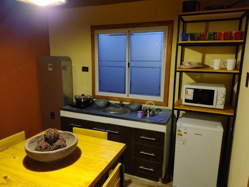 a kitchen with a table with a bowl on top of it at Cabañas Ventalia in El Calafate