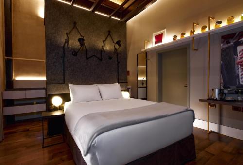 a bedroom with a large white bed in a room at Casa Firenza Hotel & Suites Boutique in Cuenca