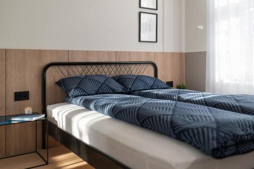 un lit avec une couette bleue et des oreillers dessus dans l'établissement Deluxe Dunavska Apartment 4, à Novi Sad