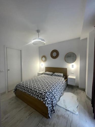 1 dormitorio con 1 cama y reloj en la pared en Renovated modern apartment in the city center, en Santa Cruz de Tenerife