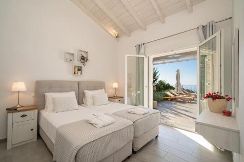 Un dormitorio con dos camas y vista al mar. en Fiscardo Luxury Stone Villa Suzana ,with sunset view!, en Fiskardho