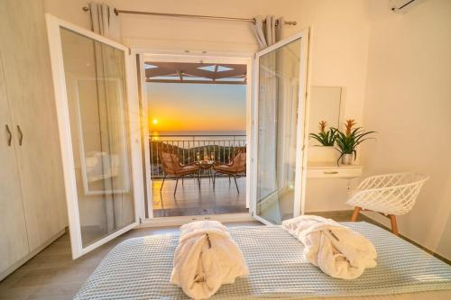 a bedroom with a bed and a view of the ocean at Fiscardo Luxury Stone Villa Suzana ,with sunset view! in Fiskardo