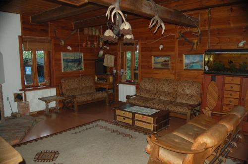 a living room with a couch and a tv in a cabin at Puszcza Romincka in Galwiecie