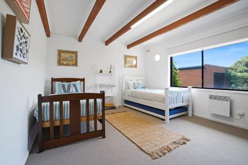 a bedroom with two beds and a window at Scotshaven in Port Fairy