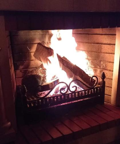 a fire in a brick fireplace with flames at Casa da Pedra in Ansião