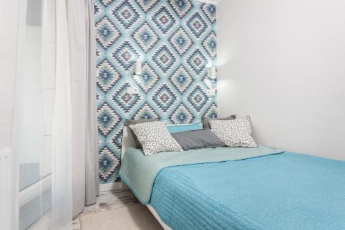 克拉科夫的住宿－Ślusarska Apartment 2，一间卧室配有一张蓝色墙壁的床