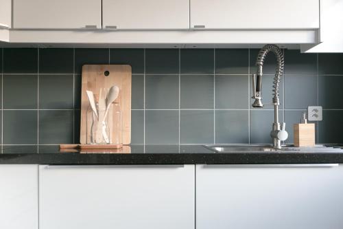 a kitchen counter with a sink and a knife block at Inn Joy Apartments Rorschach mit Panoramasicht in Rorschach