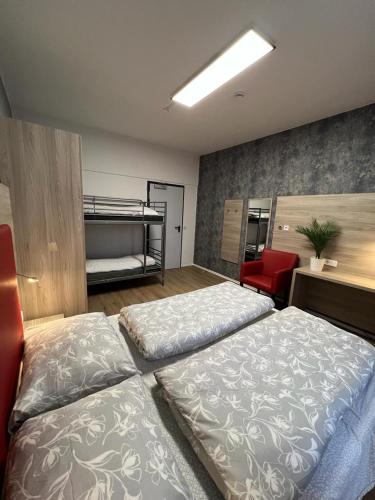 a bedroom with two beds and a red chair at Black Sheep in Cologne