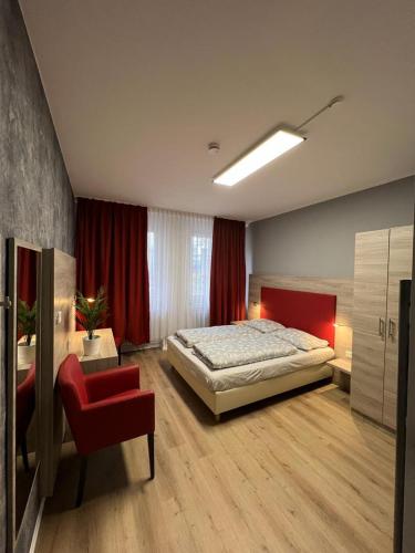 a bedroom with a bed and a red chair at Black Sheep in Cologne