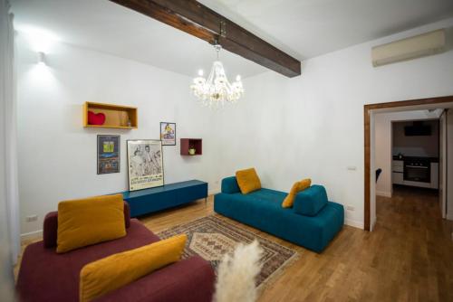een woonkamer met twee blauwe banken en een kroonluchter bij Splendido appartamento nel centro di Roma, Monti in Rome