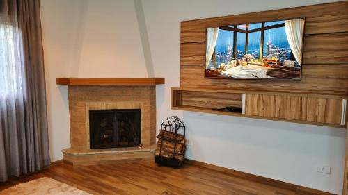 uma sala de estar com televisão e lareira em Boulevard Montreal em Monte Verde