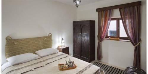 a bedroom with a large bed and a window at Dar KamalChaoui in Bhalil