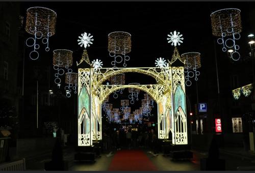 Una gran puerta blanca con luces de Navidad por la noche en Acogedor apartamento ático en el centro de O Porriño, en Porriño