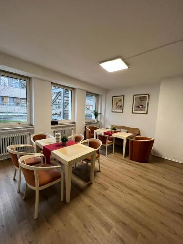 a dining room with tables and chairs and windows at Black Sheep in Cologne