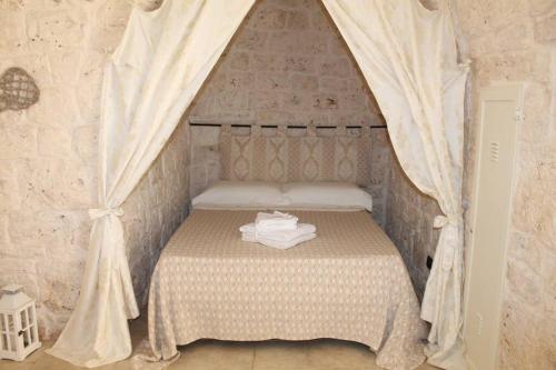Dormitorio pequeño con cama con dosel en TRULLO CHEFMARCO PRIVATE/SALTWATER SWIMMING POOL, en San Michele Salentino