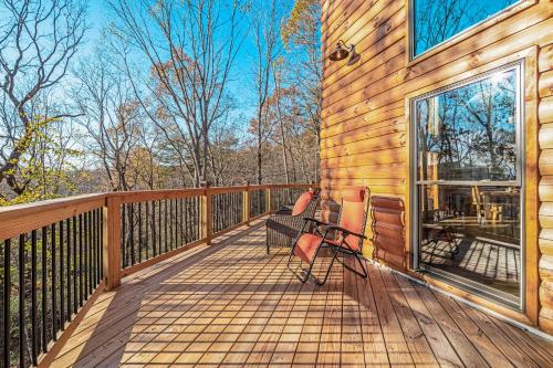 a wooden deck with two chairs on the side of a house at Cabina di Christina in Dahlonega