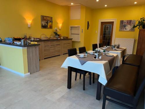 a dining room with two tables and a counter at Haus am See in Bad Sachsa