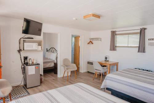 Habitación de hotel con 2 camas, mesa y sillas en Lamplighter Lodge, en Panguitch
