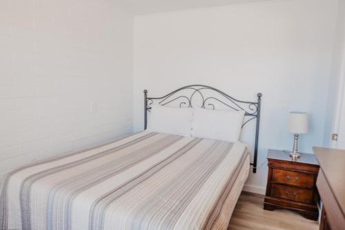 a bedroom with a bed with a metal headboard at Lamplighter Lodge in Panguitch