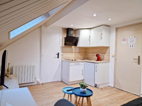 een keuken met witte kasten en een tafel en stoelen bij Castle room in Pierrefonds