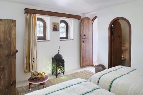 a bedroom with two beds and a fire place at Dar KamalChaoui in Bhalil