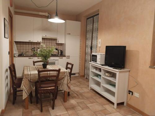 una cucina e una sala da pranzo con tavolo e TV di Residenza La Cascata a Calolziocorte
