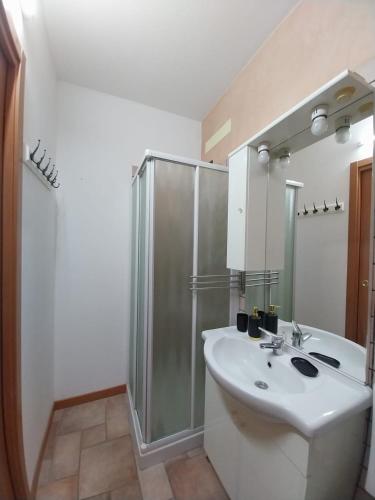 a white bathroom with a shower and a sink at Residenza La Cascata in Calolziocorte