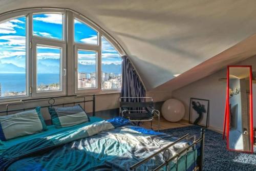 ein Schlafzimmer mit einem Bett in einem Zimmer mit Fenstern in der Unterkunft Lüks Tripleks 180° Deniz Dağ Manzaralı Merkez de in Antalya