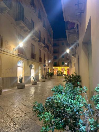 an empty street at night with some plants at AlbaChiara Suite Rooms - City Center in Trapani