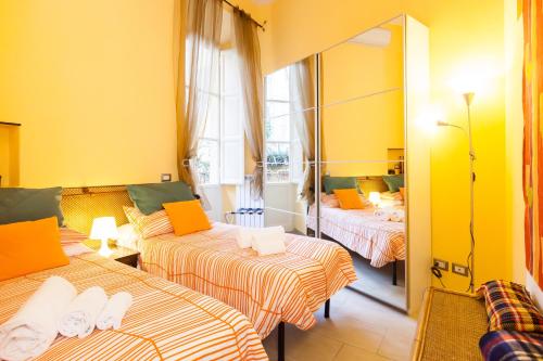ローマにあるDomus Montiのベッド3台と鏡が備わるホテルルーム