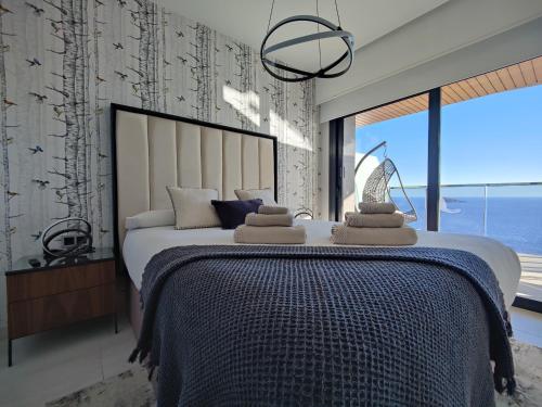 a bedroom with a large bed and a large window at SUNSET WAVES superb apartments in Benidorm