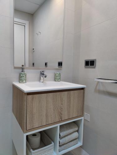 a bathroom with a sink and a mirror at SUNSET WAVES superb apartments in Benidorm