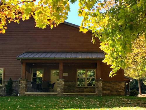 a house with two chairs on the porch at Sojourner's Lodge & Log Cabin Suites in Dundee