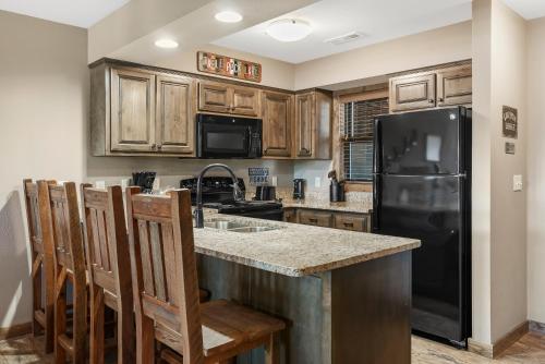 a kitchen with wooden cabinets and a black refrigerator at Table Rock Resorts at Indian Point in Branson