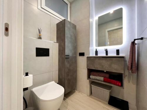 a bathroom with a toilet and a sink and a mirror at El Dorado 114 luxury with full air-conditioning in Playa de las Americas