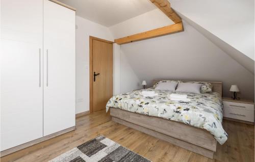 een slaapkamer met een bed en een houten vloer bij Cozy Home In Otocac With Wifi in Otočac