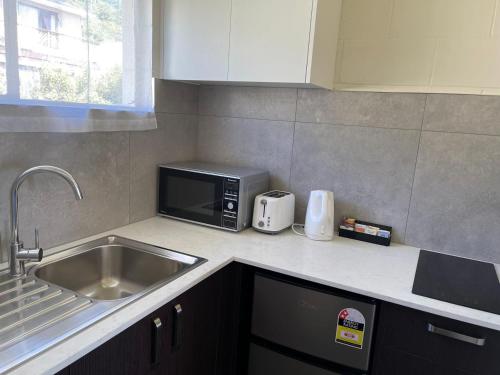 a kitchen with a sink and a microwave at Blue Seas Motel in Kaikoura