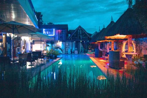 a swimming pool at a resort at night at Blue Moon Inn in Dauis