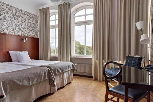 sypialnia z łóżkiem, krzesłem i oknem w obiekcie Best Western Plus Grand Hotel w mieście Halmstad